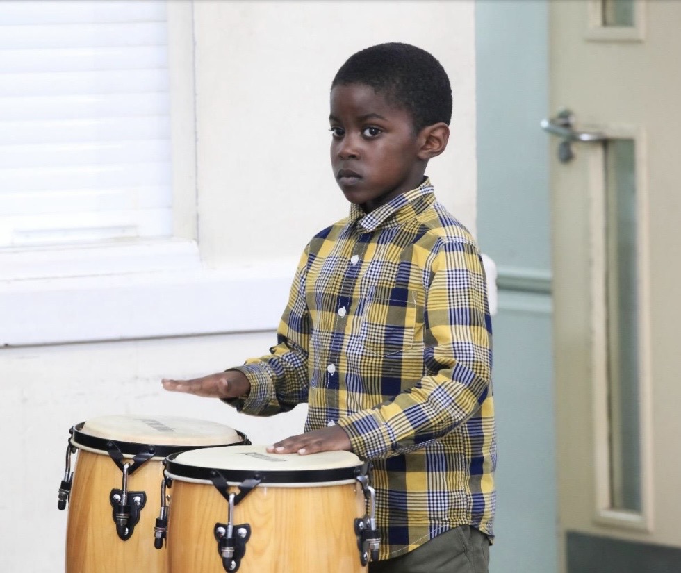 Young drummer playing the bongos